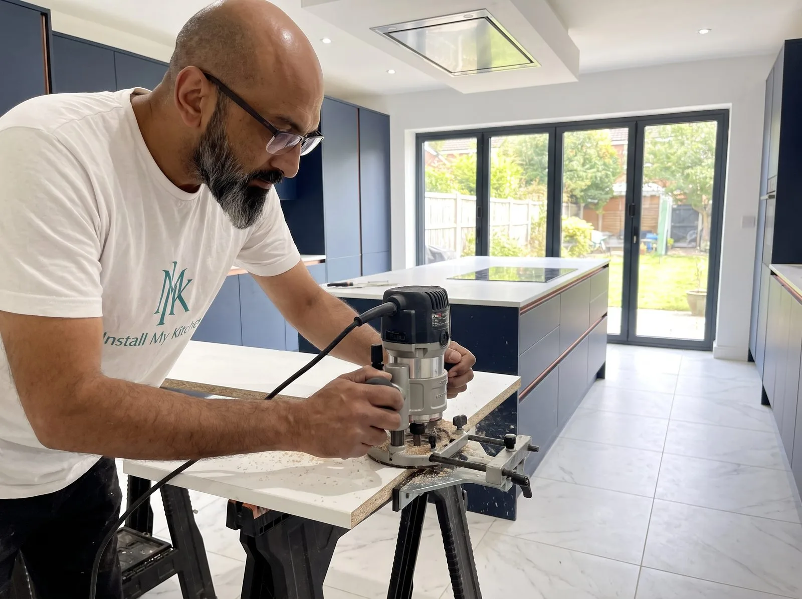 Kitchen fitter using a router in a worktop jointing jig on trestles