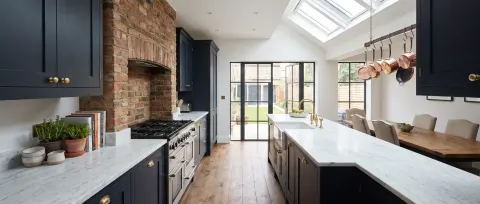 Luxury navy kitchen with marble worktops and brass fittings