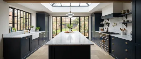 Luxury kitchen with marble island and bifold doors to garden